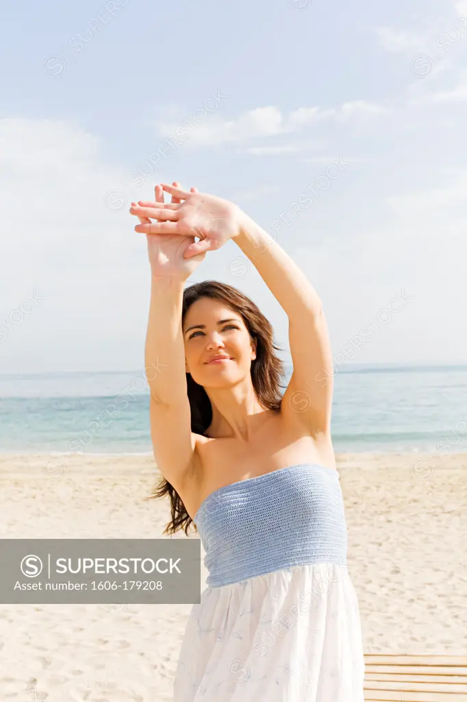 Portrait of a brunette woman covering from the sun at the beach