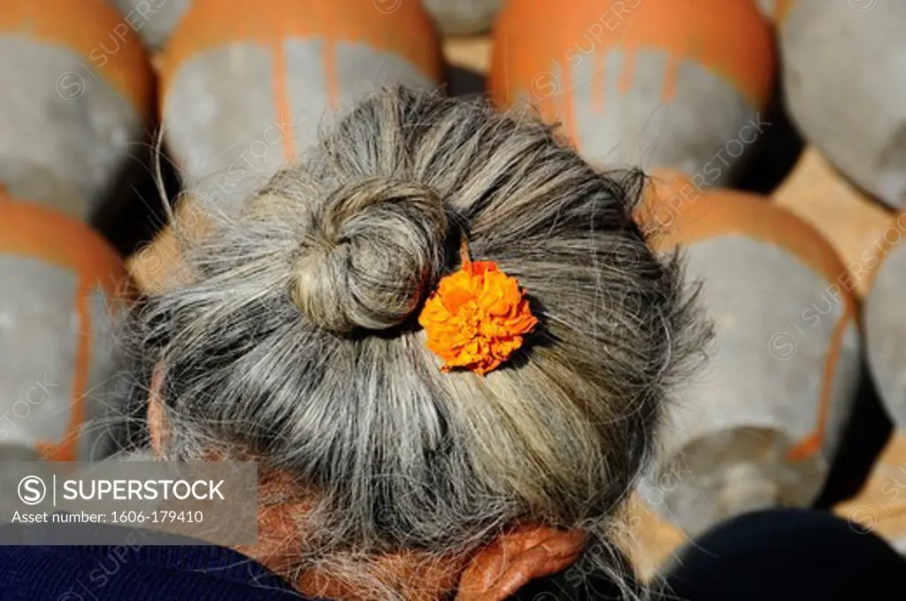 Nepal Kathmandu an orange flower in an old lady chignon