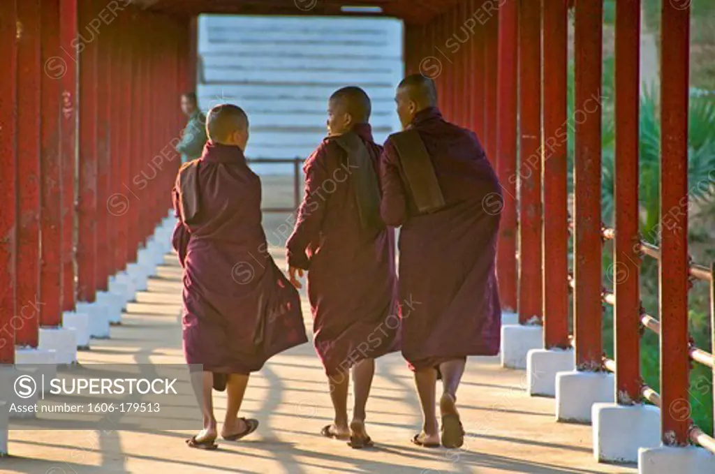 Burma BAGO 3 young monks wearing a purple toga are walking side by side