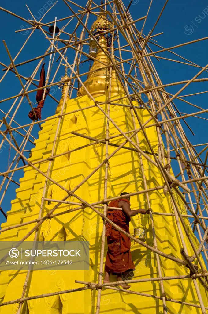 Myanmar Burma HPA AN 2 monks are working on a bamboo scaffolding painting in yellow the stupa of a pagoda