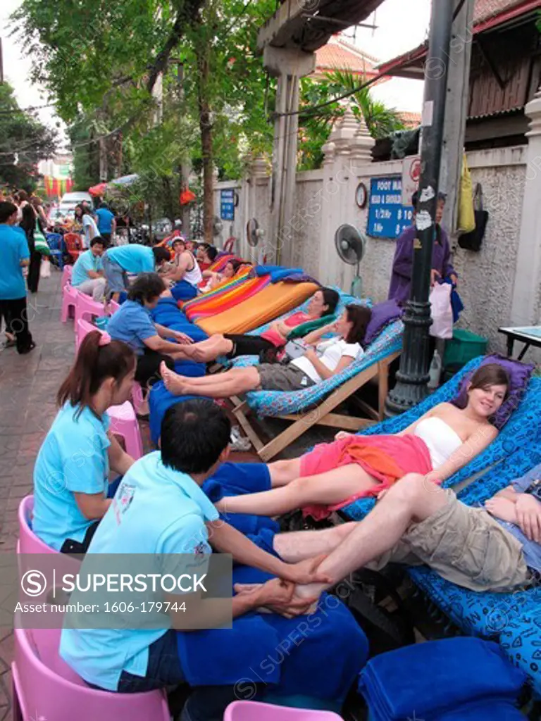 Tourists having a foot massage in the khao san road street in Bangkok