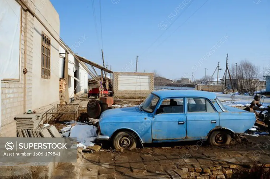 /UZBEKISTAN KHIVA an old blue russian car is abandoned in the poor subur outside of KHIVA