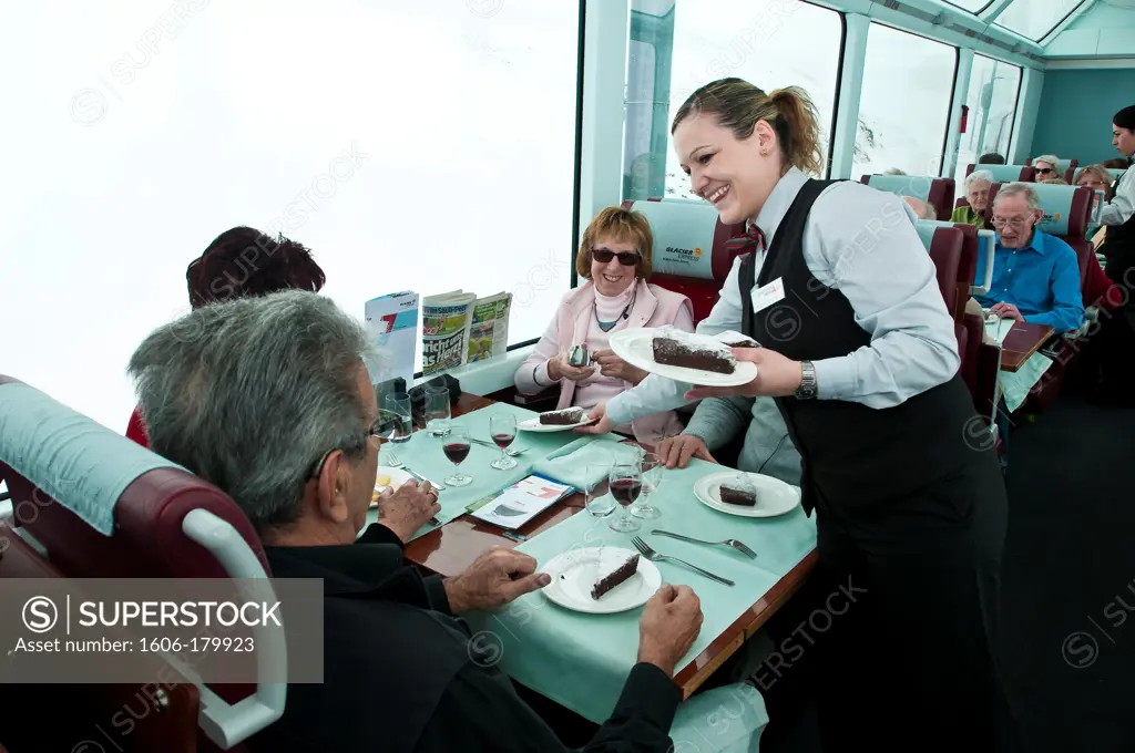 Europe, Switzerland, Alpes mountains, Grisons Province (GR), inside the Glacier Express train, passengers talk with the waitress Margarida Gonzales working on board since 5 years