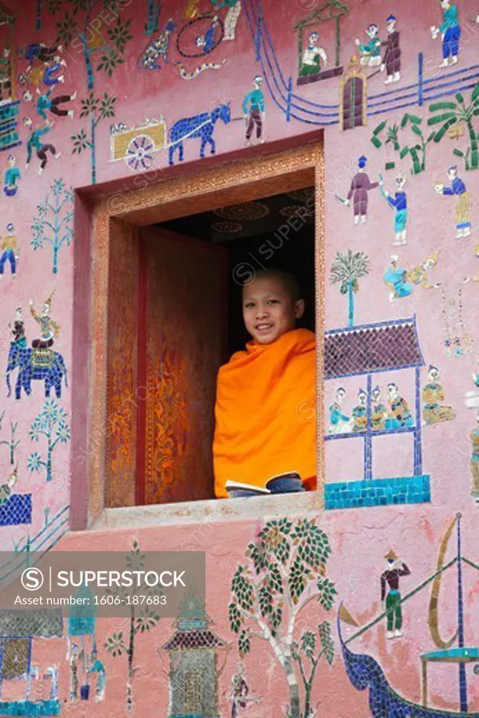 Laos,Luang Prabang,Wat Xieng Thong,Monk at Window of the Reclining Buddha Sanctuary aka The Red Chapel