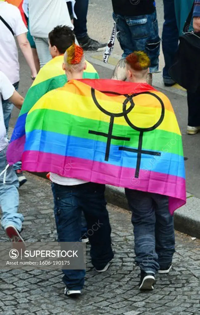 Two men with a pride flag draped around his shoulders in Paris Gay Pride Parade in France,Europe
