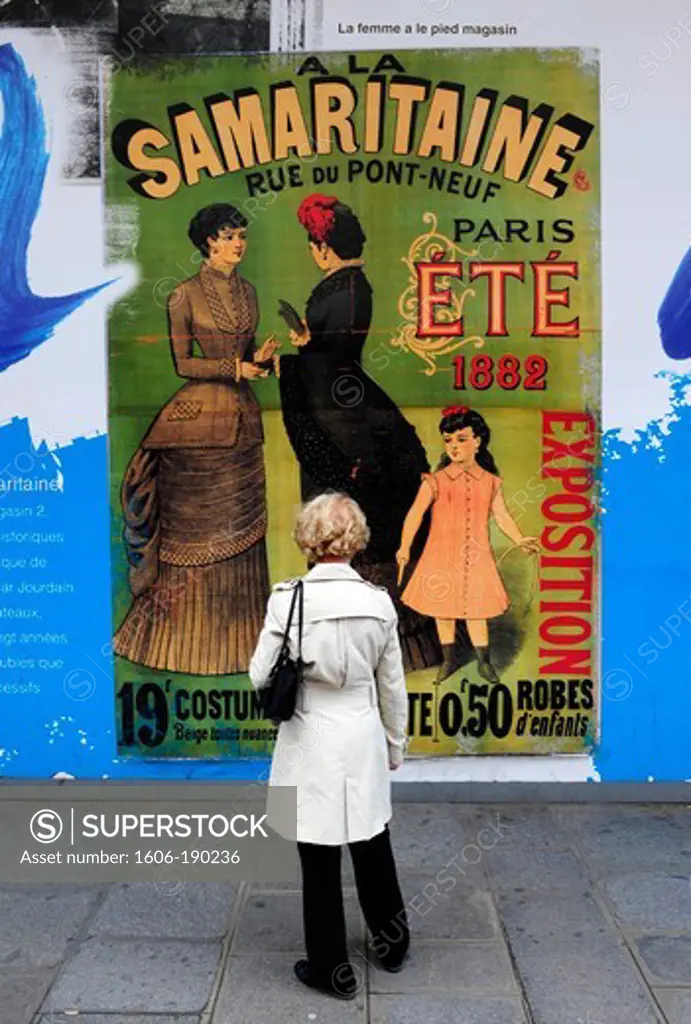 Woman looking a old poster of Samaritaine in Paris,France,Europe