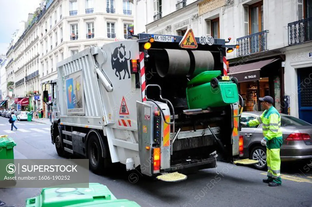 Garbage vehicle is picking up trash in front of a home in Paris downtown,France,Europe