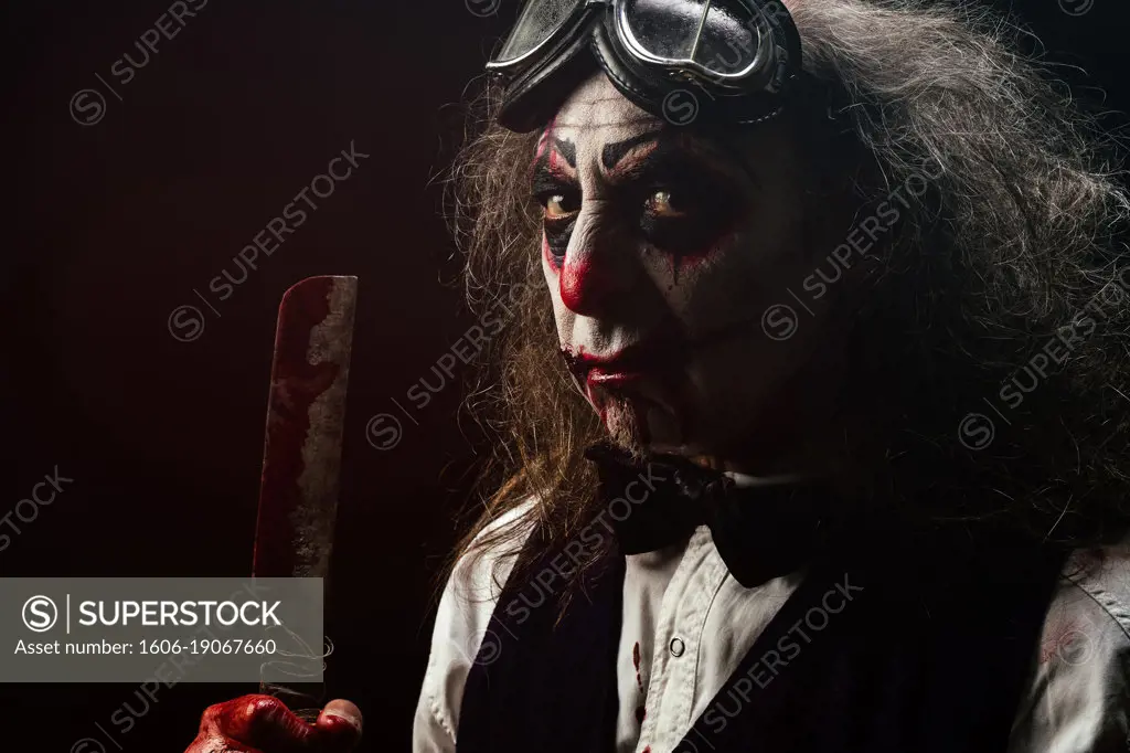Portrait of a nasty clown, a bloody knife in his hand