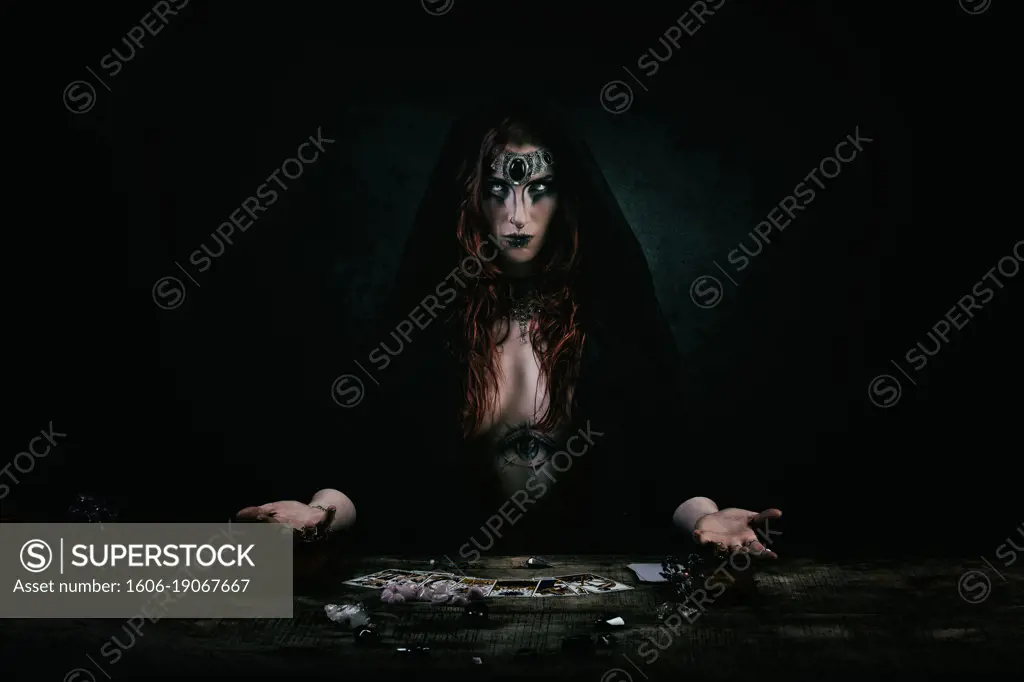 Portrait of a witch in front of her tarot game