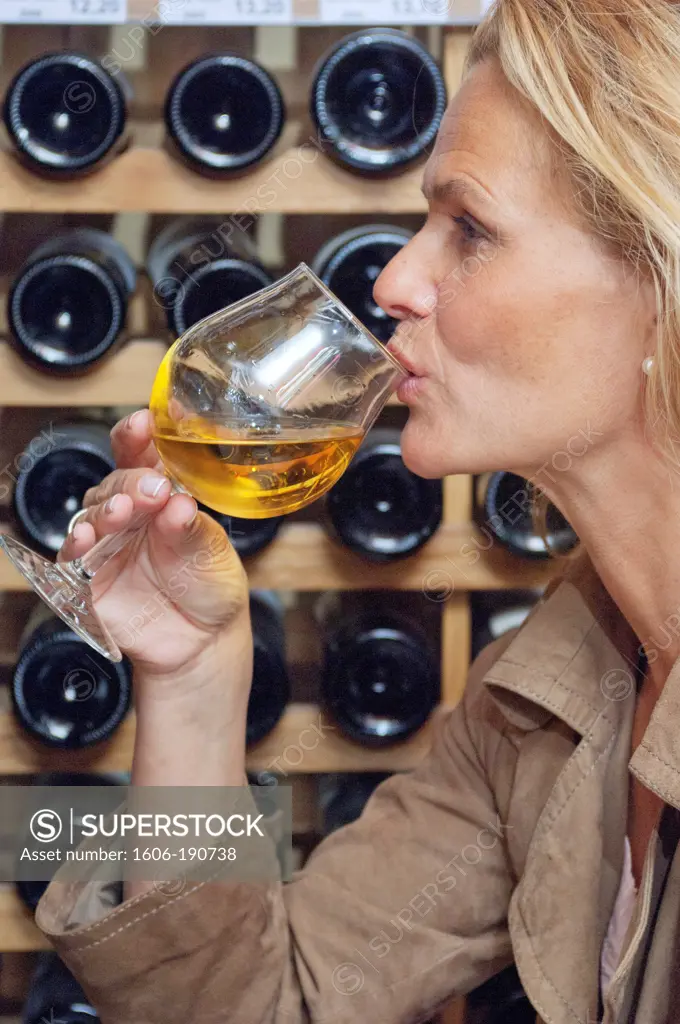 Woman profile, holding a glass of white wine, close up