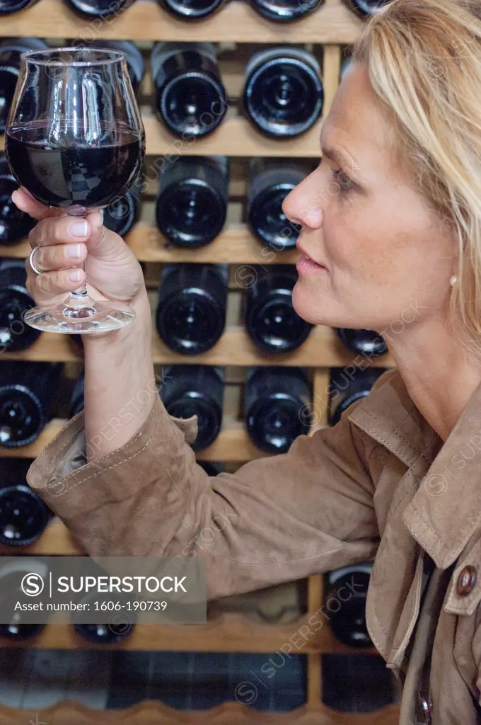 Woman profile, holding a glass of red wine, close up