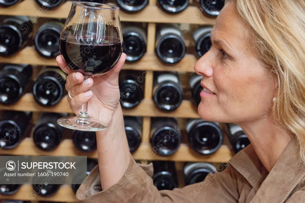 Woman profile, holding a glass of red wine, close up