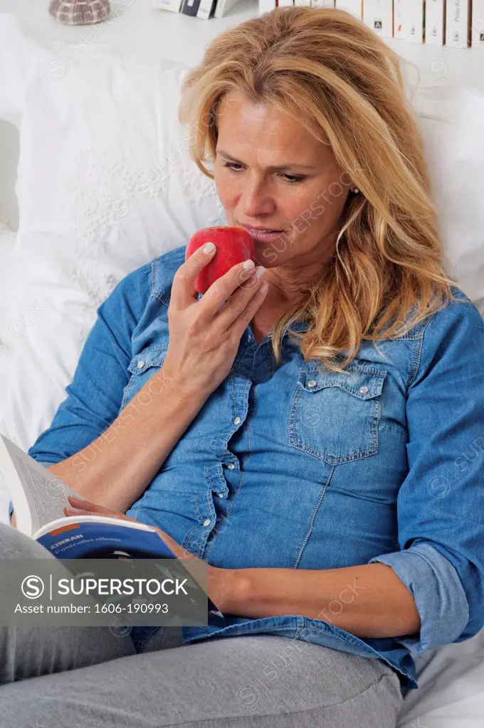 Caucasian woman eating a red apple