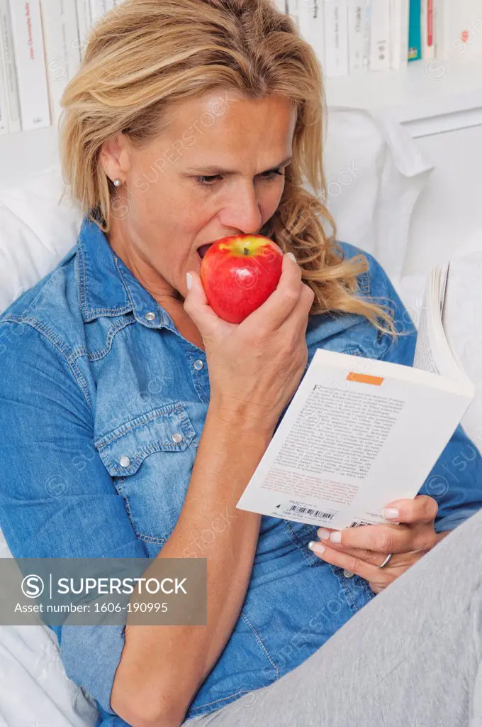 Caucasian woman eating a red apple