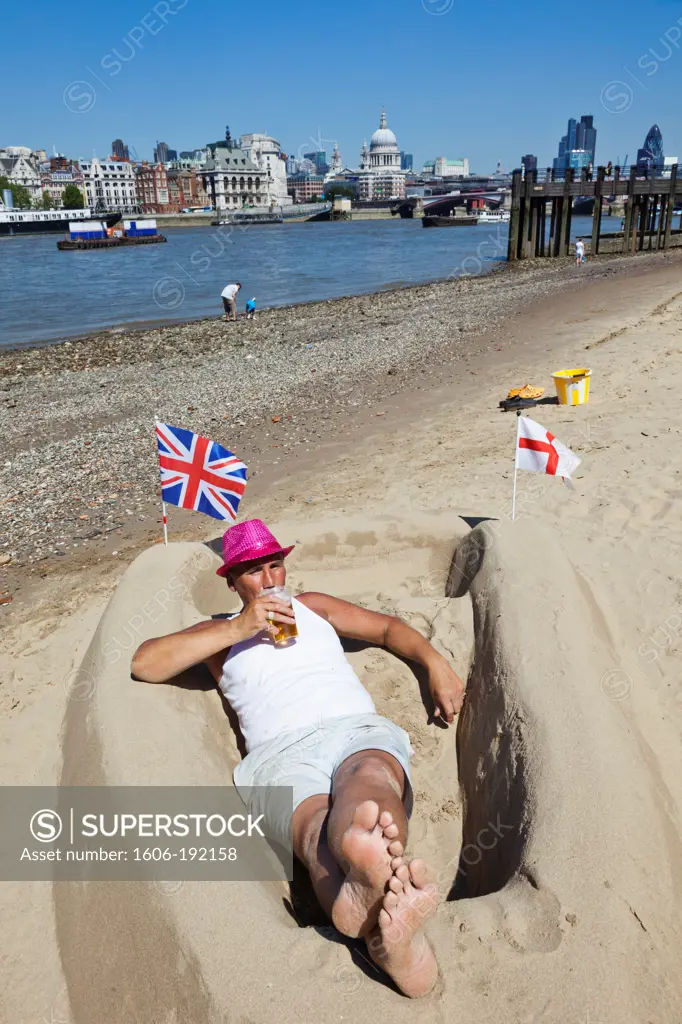 England,London,Bankside,Sand Sculpture Artist Relaxing on Bank of River Thames