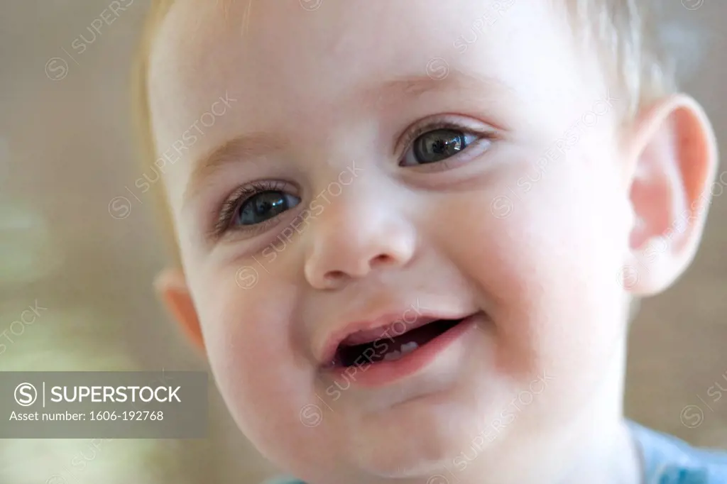 Close Up Of Blond Baby Smiling With His Two Teeth