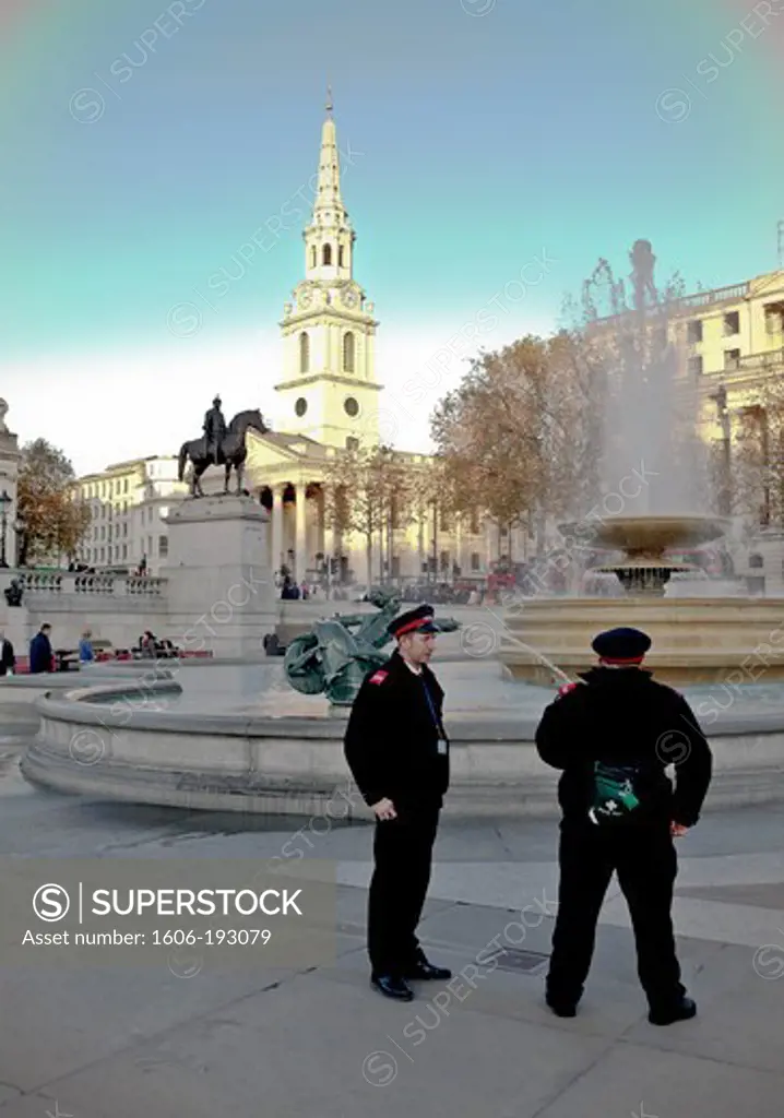 England, London, Trafalgar Square, Policemen In Front Of A Foutain And The St Martin-In-The-Fields' Church In The Background