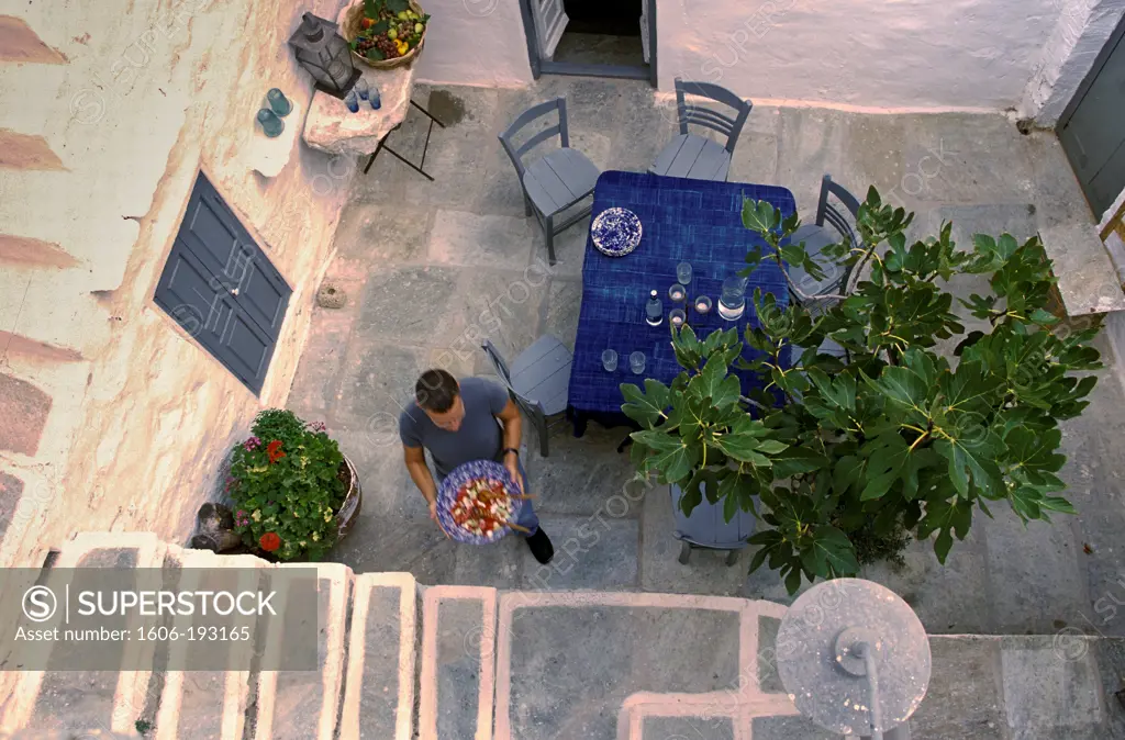 Greece, Serifos Island, Boy Carrying A Salad Bowl In A Private Courtyard, View From Above