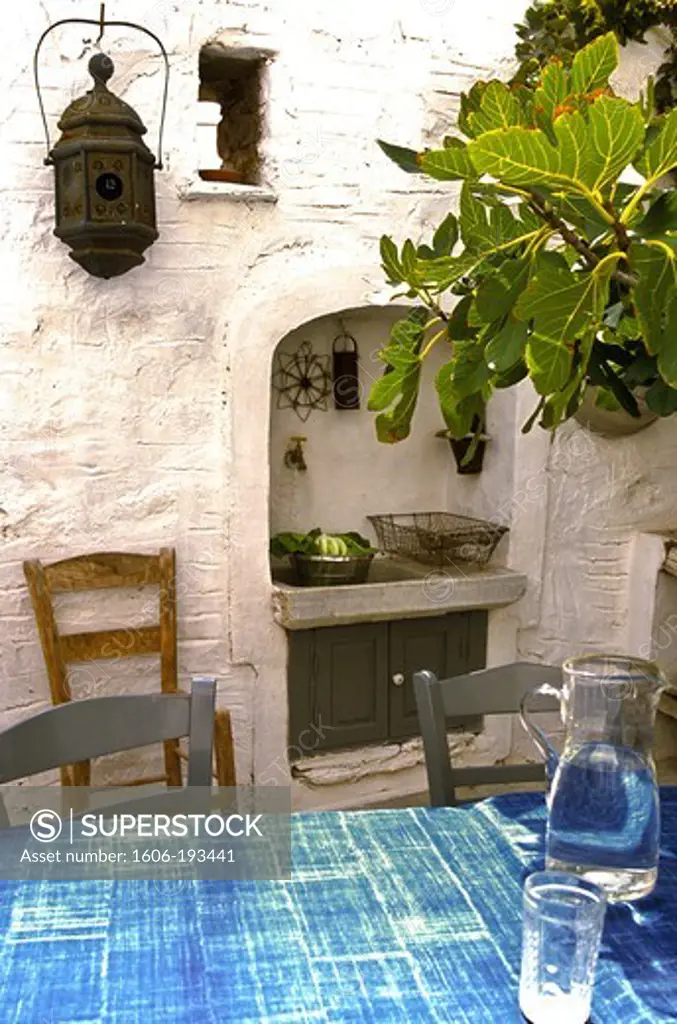 Greece, Serifos Island, Courtyard With An Outdoor Kitchen, Blue Table With Carafe And Figtree