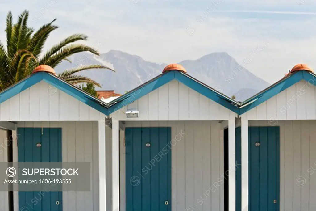 Italy, Forte Dei Marmi, White Beach Huts With Blue Doors, Palm Tree And Mountains In The Background