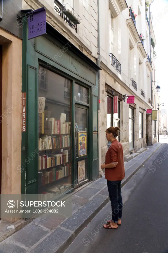 France, Paris, Young Woman In Front Of A Bookshop In Le Marais (4Th Arrondissement)