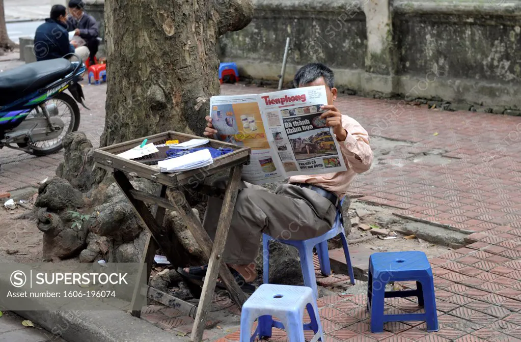 Man Reading A Newspapper In A Street Of  Hanoi, Vietnam, South East Asia, Asia