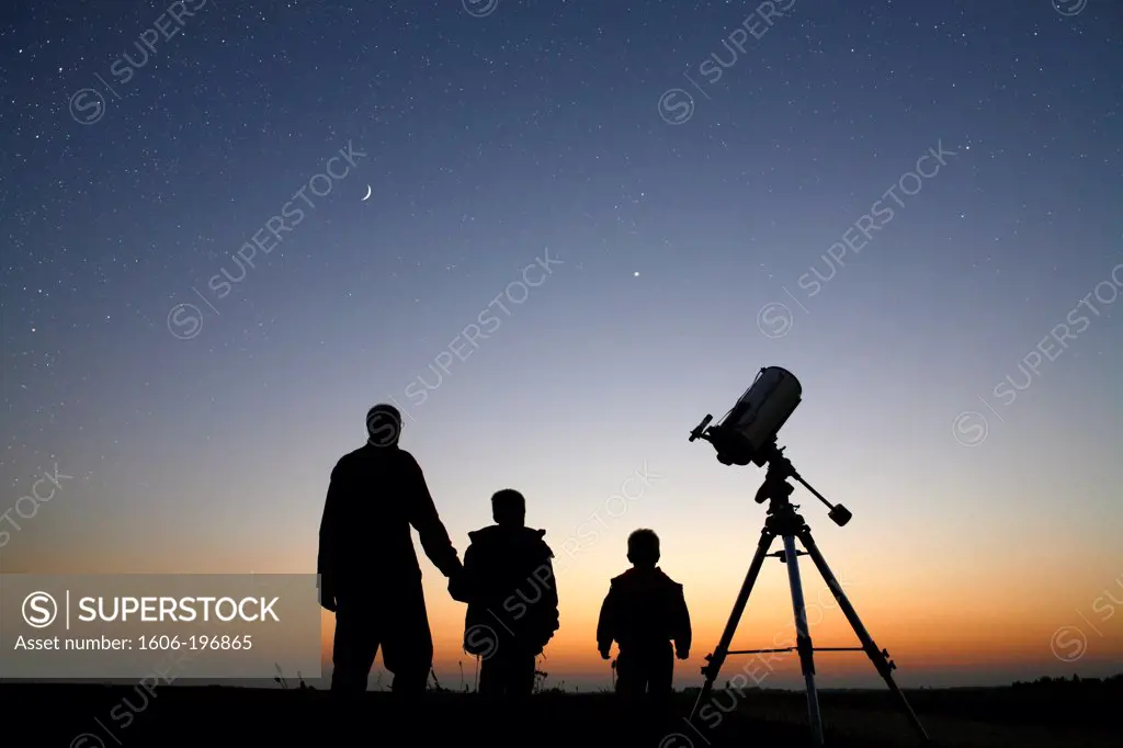France. Seine Et Marne. Man And Children With A Telescope Watching The Moon During The Twilight.