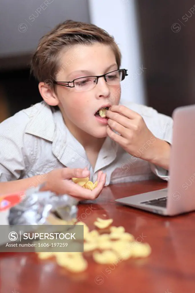 France, Young Boy With A Computer And Chips.