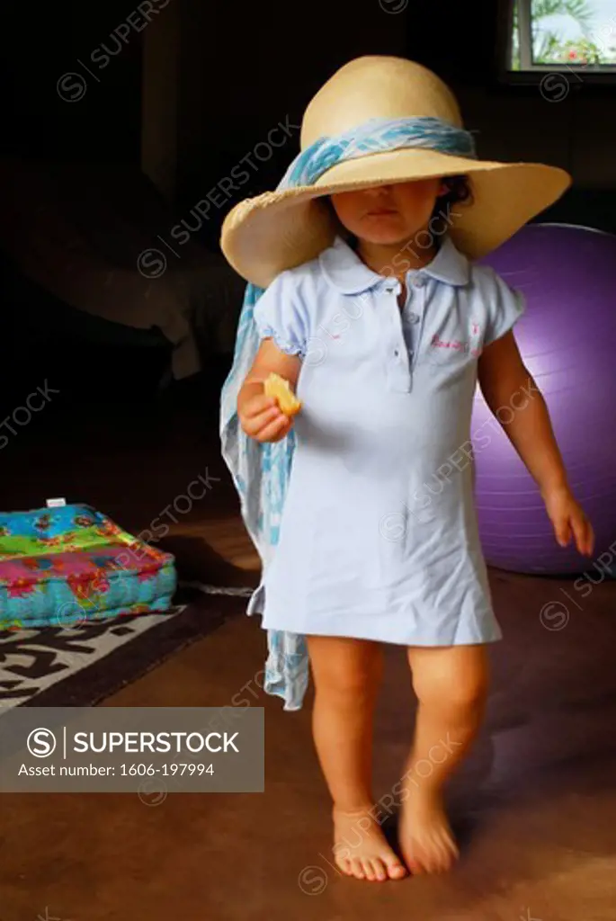 Young Girl  Walking With A Straw Hat And Eating A Biscuit