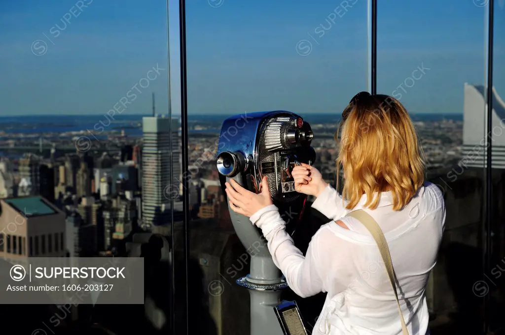 Woman Looking On Binocularsfrom The Top Of The Observation Deck On Rockefeller Building In New York City, New York State, United State, Usa