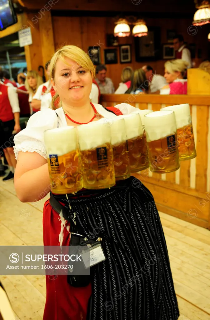 Female Waiter With Beer Steins During  Oktoberfest Festival In Munich, Germany