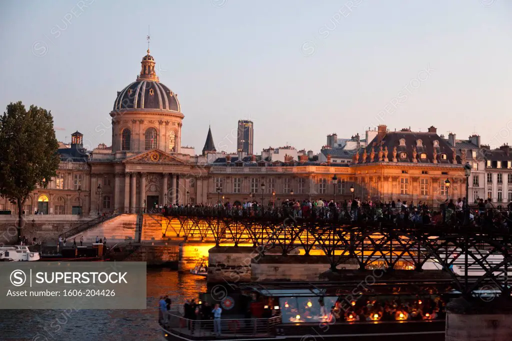 France. Paris. 1st district,  Pont des Arts, Groups of people gathered for outdoor meal at dusk