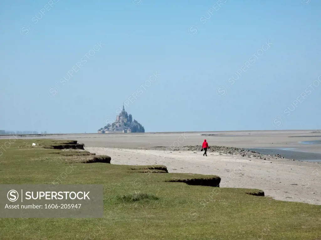 France, Normandy, young lady walking towards Mont St Michel at low tide.