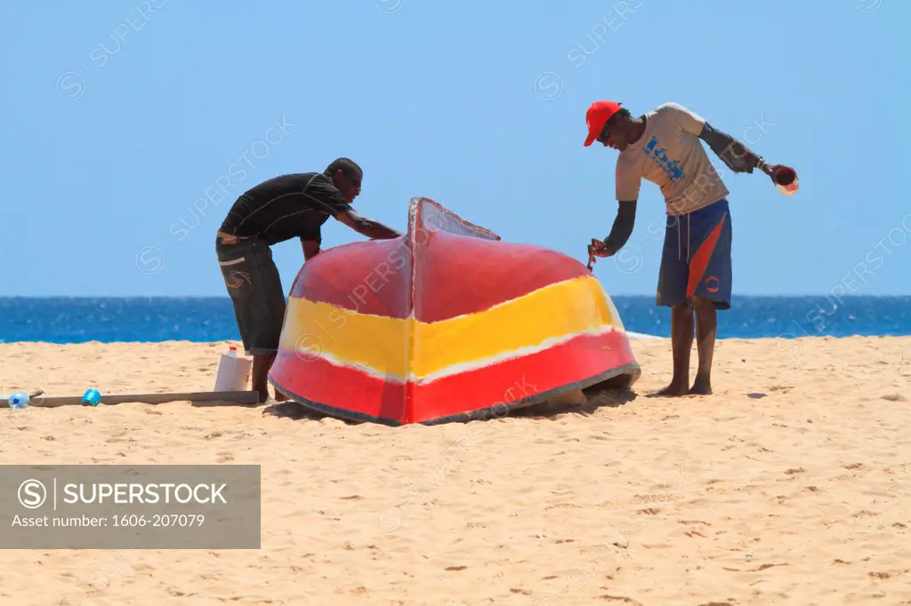 Western Africa,Republic of Cape Verde, Sal island. Santa Maria.Fishermen painting a boat.