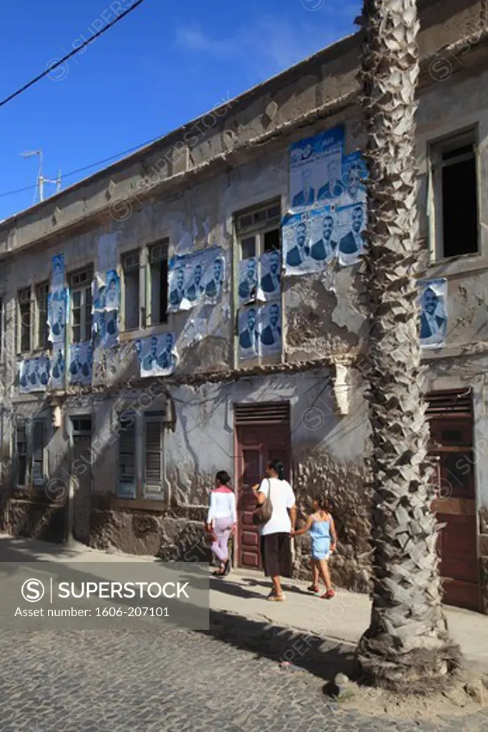 Western Africa,Republic of Cape Verde, Sal island. Santa Maria. Family walking in front of an used wall.
