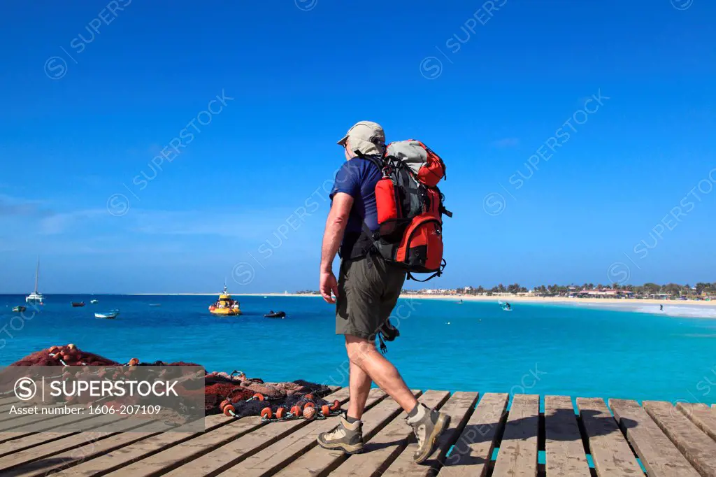 Western Africa,Republic of Cape Verde, Sal island. Santa Maria. Senior walking on the jetty.