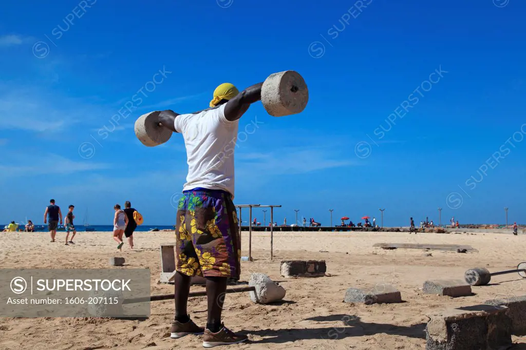 Western Africa,Republic of Cape Verde, Sal island. Santa Maria. People exercising on village beach.