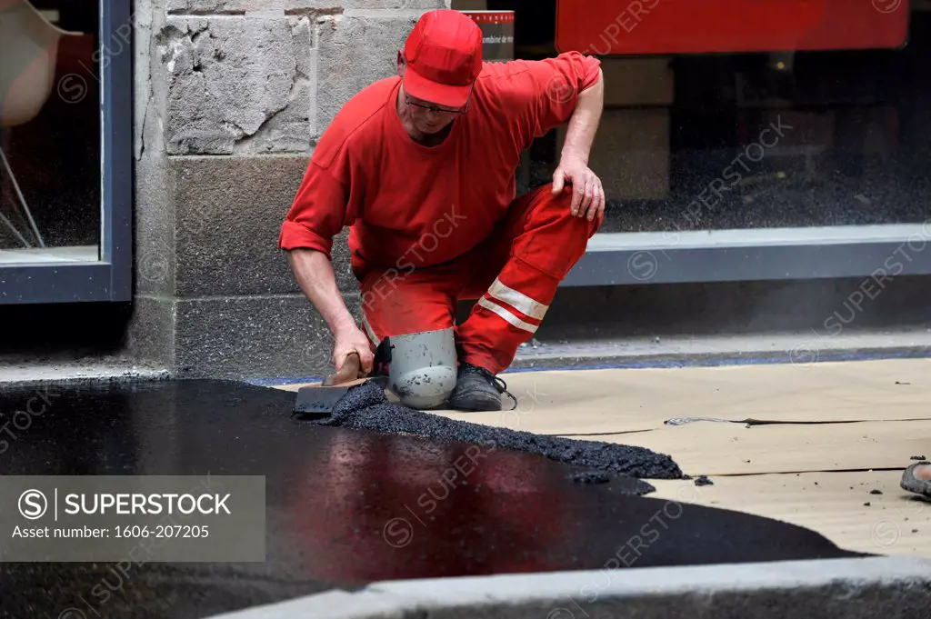 France, surfacing of the roadway in a street, laying the asphalt bitumen on a sidewalk in Nantes city.