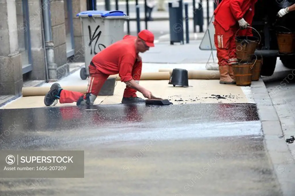 France, surfacing of the roadway in a street, laying the asphalt bitumen on a sidewalk in Nantes city.