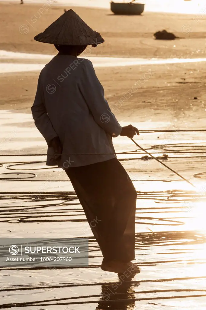 Vietnam,Mui Ne,Mui Ne Beach,Net Fisherwoman at Dawn