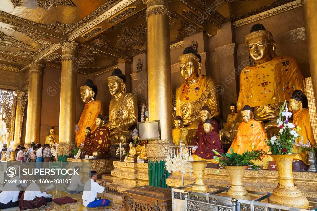 Myanmar,Yangon,Shwedagon Pagoda,People Praying in front of Buddha Statues