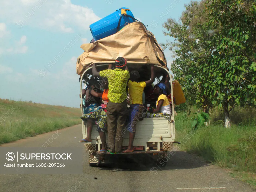TOGO a group of adults are travelling standing up in the back of a truck