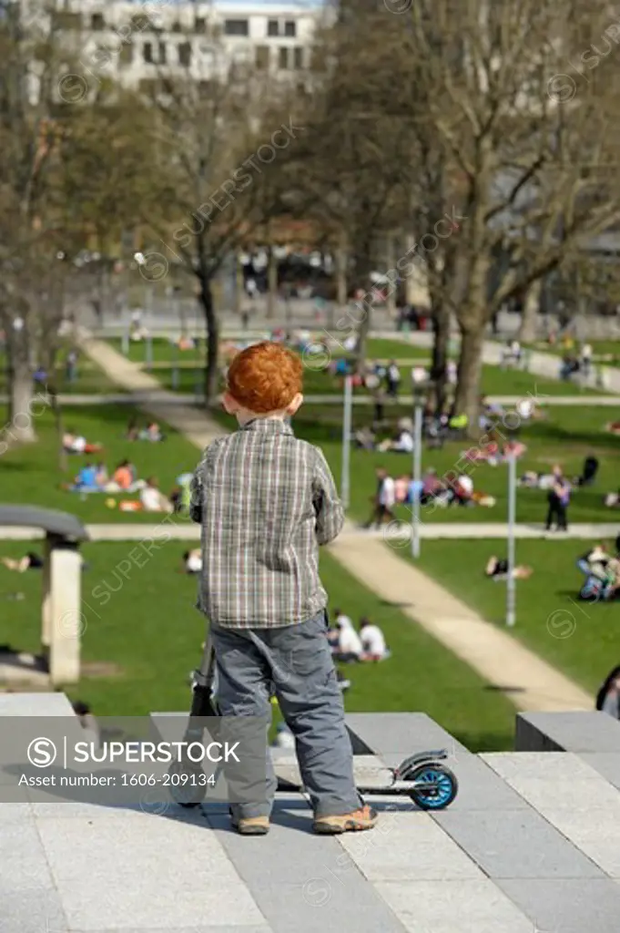 France, Paris, redhead child at park.
