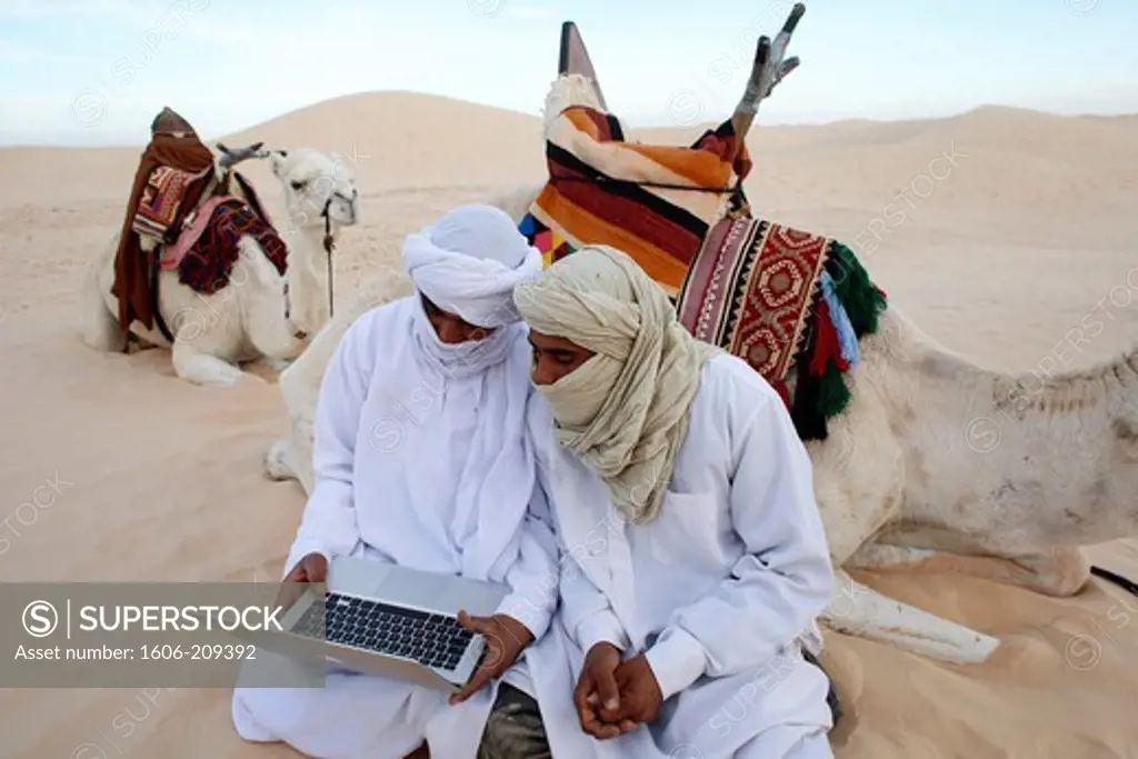 Africa, Tunisia,Beduins using a laptop in the Sahara Tunisia.