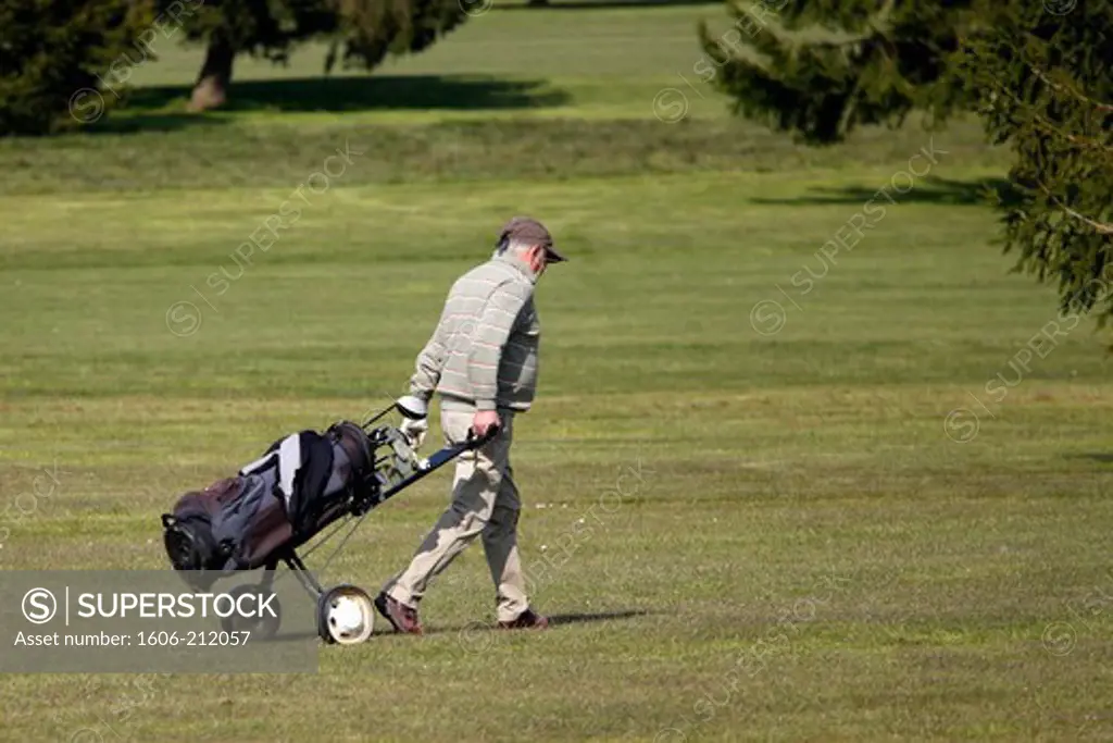 France, Crecy la Chapelle. Golf. Retired man walking with his caddy.