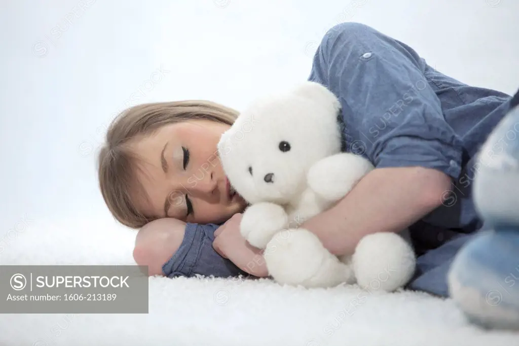 France, young woman sleeping with teddy bear.