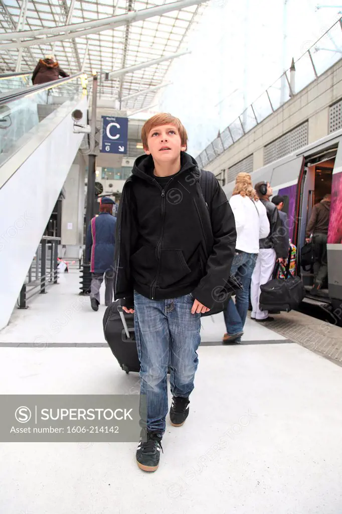 France, Paris, young boy with luggage at CDG railway station.