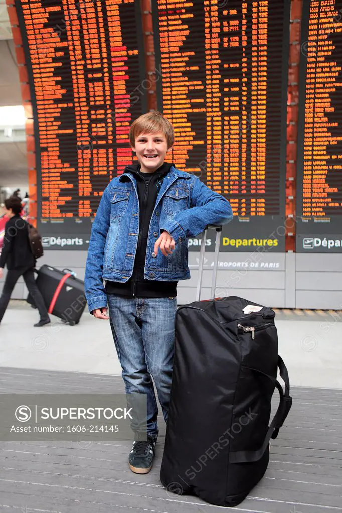 France, Paris, CDG airport. Young boy with luggage.