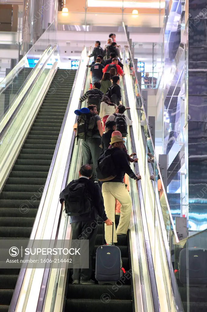 UAE, Dubaï airport. Travelers using escalators.