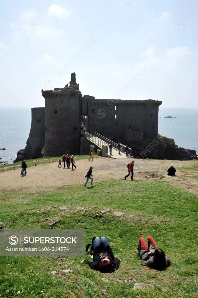 France, Vendée, Yeu island, Old Castle on the wild coast (14th century), visitors sitting in the foreground.